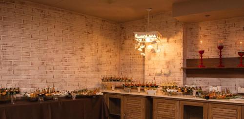 a room with a brick wall and a counter with bottles of wine at Triada Hotel in Sofia
