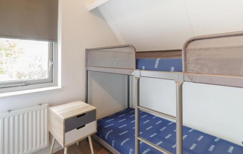 two bunk beds in a small room with a window at Beautiful Home In Wemeldinge With Wifi in Wemeldinge