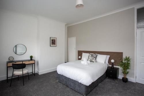 una camera con letto bianco, scrivania e letto sidx sidx. di Stylish 2 Bed Home Wifi Smart Tv a Spennymoor