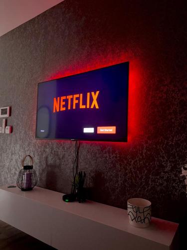 un televisor con la señal de netflix en una pared en APARTMAN 3, en Brčko