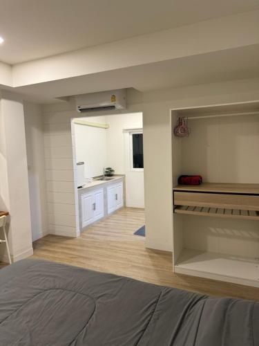 a room with a bed and a kitchen in it at The comfy cave in Ban Klang