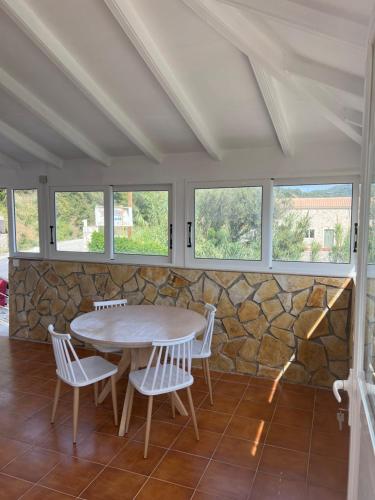 a table and chairs in a room with a stone wall at Hamre Apartments (Nicholas) in Agios Georgios Pagon