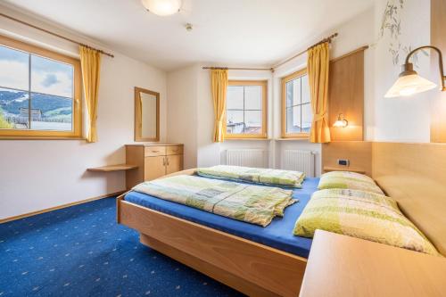 Duas camas num quarto com janelas e alcatifa azul em Residence Oberhauser Apt 3 em Valdaora