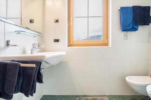 uma casa de banho branca com um lavatório e um WC em Residence Oberhauser Apt 3 em Valdaora