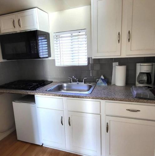 a kitchen with a sink and a microwave at Unit 4 - Walkable Roosevelt Row 1BR 1BA Downtown Stay in Phoenix