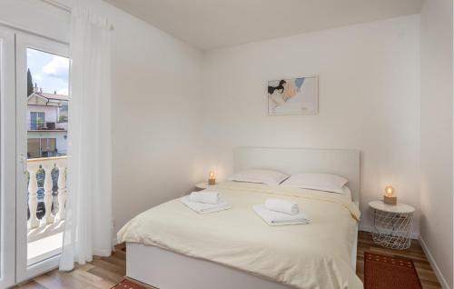 a white bedroom with a bed and a window at Cozy Apartment In Selce With Kitchen in Selce