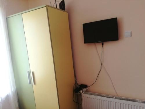 a bedroom with a cabinet with a television on the wall at Вила Кичево in Varna City