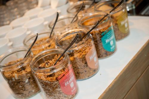 a group of jars filled with food on a counter at Novotel Rotterdam Brainpark in Rotterdam