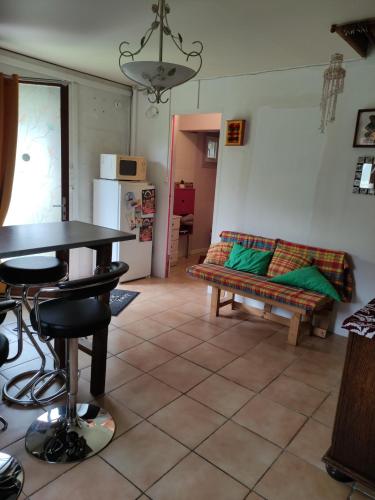 een woonkamer met een tafel en een bank bij La Désirade in Montmirail