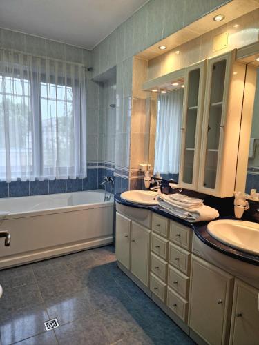 a bathroom with two sinks and a bath tub and a tubermottermott at Crama Haiducilor in Cluj-Napoca