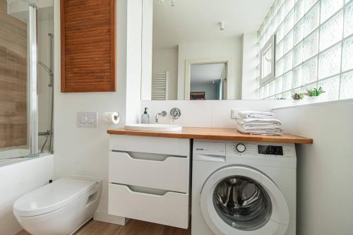 a bathroom with a washing machine and a sink at Apartment by the Castle - top spot in Szczecin in Szczecin