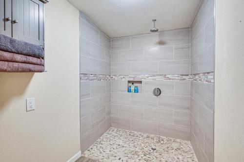 a bathroom with a walk in shower with tile at Updated El Centro Home with Private Patio in El Centro
