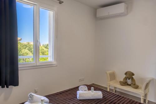 un ours en peluche assis sur une chaise dans une pièce avec une fenêtre dans l'établissement E Case Olivia Casa 2, à Monticello