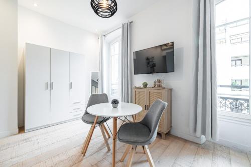 - un salon blanc avec une table et deux chaises dans l'établissement Cozy 1 Bdr Downtown, à Nice