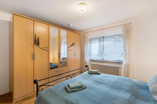 Schlafzimmer mit einem Bett und einem Holzschrank in der Unterkunft Ferienwohnung Murgperle in Gernsbach