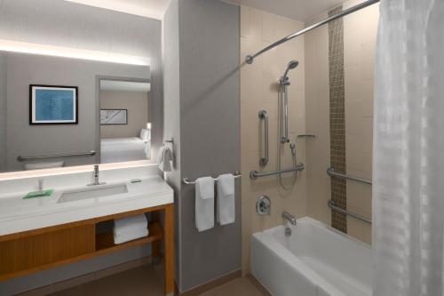 ein Bad mit einer Badewanne, einem Waschbecken und einer Dusche in der Unterkunft Hyatt Place Denver Cherry Creek in Denver