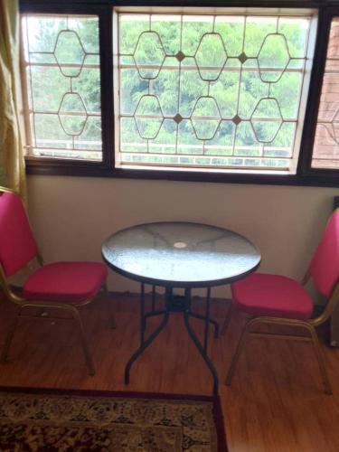 una mesa y dos sillas frente a una ventana en Lakeview Serenity en Entebbe