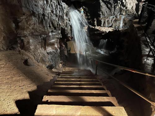 a staircase leading to a waterfall in a cave at Entire Venue Hire with 8 Bedroom Accommodation - Your Own Pub Experience in Swansea