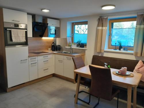 a kitchen with a wooden table and a kitchen with a table and a tablektop at Appartements Kumming in Rauris