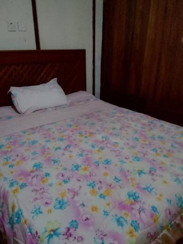 a bed with a flowery comforter on it at Lakeview Serenity in Entebbe