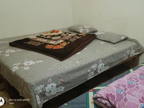 un letto con una coperta sopra di Hotel vikash a Barkot