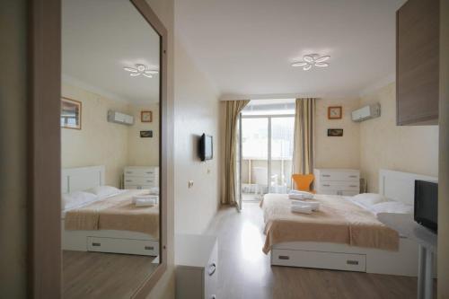 um quarto com 2 camas e um espelho em Orbi Residence Apartments em Batumi