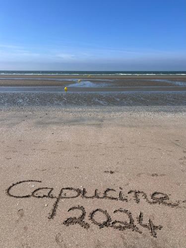 a sign written in the sand on a beach at Chambres chez l'habitant Capucine in Honfleur