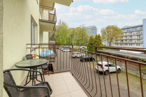 uma varanda com uma mesa e vista para um parque de estacionamento em Apartamenty Morskie Oko SeaView by Rent like home em Międzyzdroje