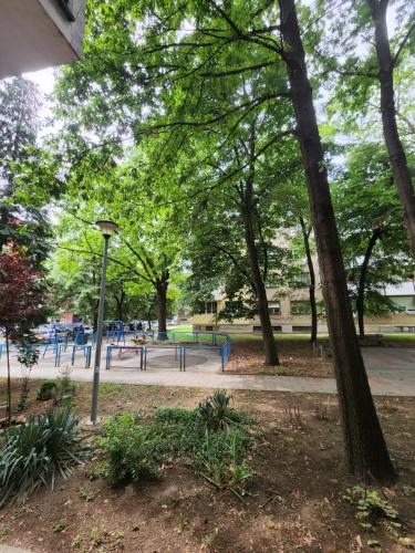a park with a playground with trees and a light pole at Nancy's Cozy Business Apartment in Bežanija