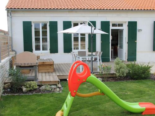 un toboggan pour enfants dans la cour d'une maison dans l'établissement LOCATION Les Lisettes N1, à La Cotinière