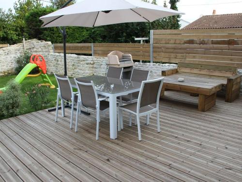 - une table avec des chaises et un parasol sur une terrasse dans l'établissement LOCATION Les Lisettes N1, à La Cotinière