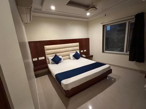 a bedroom with a large bed with blue pillows at Hotel Sapphire At New Delhi Railway Station in New Delhi