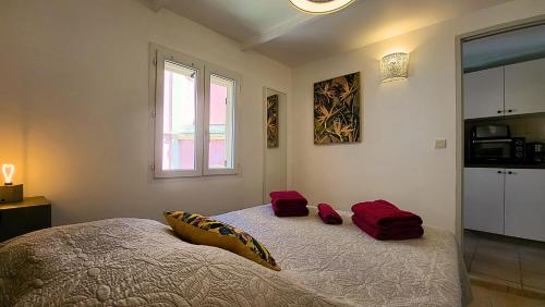 Un dormitorio con una cama con almohadas rojas. en Appartements de l'Eglise, en Calvi
