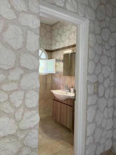 uma casa de banho com um lavatório e uma parede de pedra em Hamre Apartments (Nicholas) em Agios Georgios Pagon
