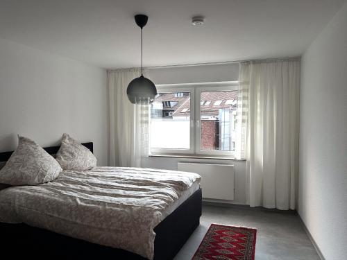 een slaapkamer met een bed en een raam bij Penthouse Apartment Dortmund City in Dortmund