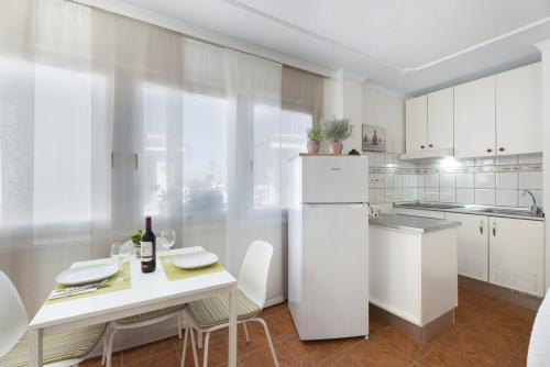 a kitchen with a white refrigerator and a table with chairs at Villa Barca in El Médano