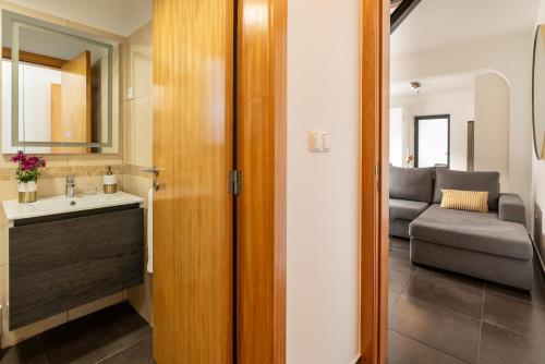 a bathroom with a sink and a living room at Melblue in Estreito da Calheta