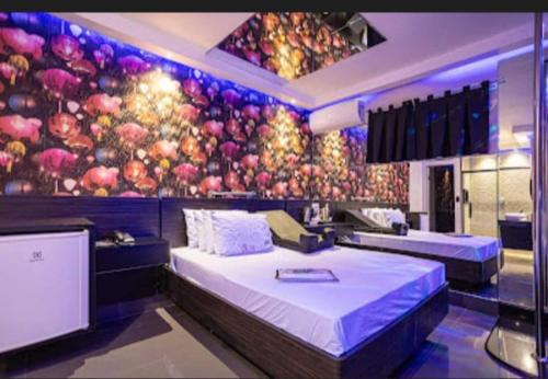 a room with two beds and a painting of apples at Motel Desireé in Sao Paulo
