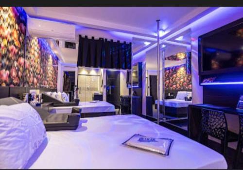 a hotel room with two beds and a room with purple lights at Motel Desireé in Sao Paulo