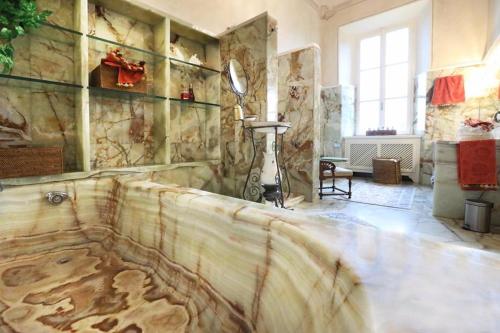 a room with a stone wall with a bath tub at Villa Ghiringhelli in Azzate