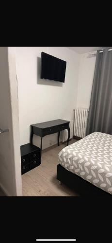 une chambre avec un lit et un bureau avec une télévision dans l'établissement Chambre, à Beauvais