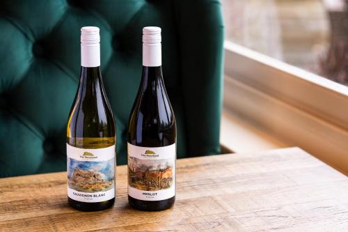 two bottles of wine sitting on a wooden table at The Moorland Hotel, Haytor, Devon - The Coaching Inn Group in Haytor