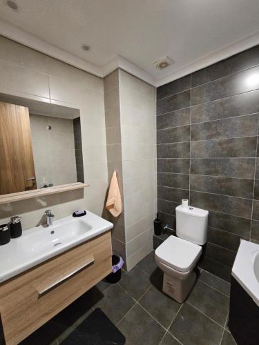 La salle de bains est pourvue de toilettes, d'un lavabo et d'un miroir. dans l'établissement MIA Appartement - résidence les champs du printemps, à Casablanca