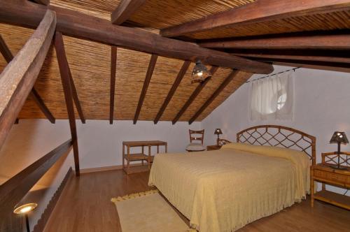 1 dormitorio con 1 cama en una habitación con techos de madera en Cuevas Morenas, en Teror