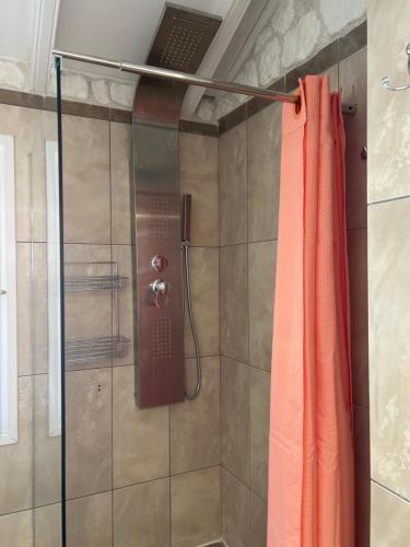 a shower with a red shower curtain in a bathroom at Hamre Apartments (Nicholas) in Agios Georgios Pagon