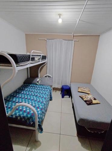 ein kleines Zimmer mit einem Etagenbett und einem Sofa in der Unterkunft Hostel Cápsula Pousada Avenida G20 in Canoinhas