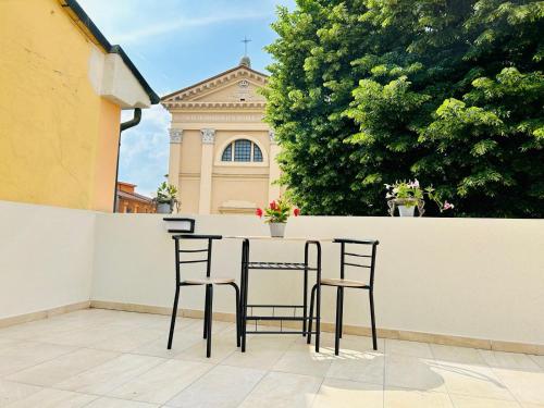 a table and chairs in front of a building at SMART SUITES FORLI' in Forlì