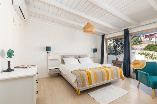 a white bedroom with a bed and a table and chairs at Sa Dommu e Mare in Santa Maria Navarrese