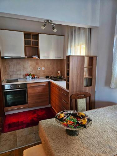 eine Küche mit Holzschränken und einer Schüssel auf einem Tisch in der Unterkunft Apartman Jovanovic in Vrnjačka Banja