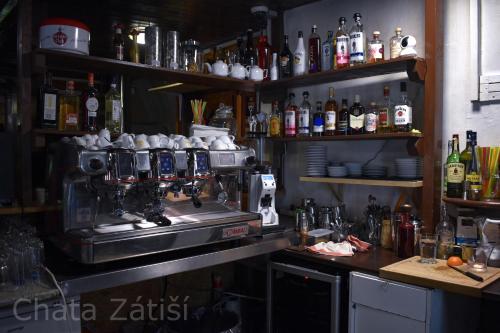 a kitchen with a bar with a coffee machine at Penzion chalupa Lesní zátiší in Harrachov